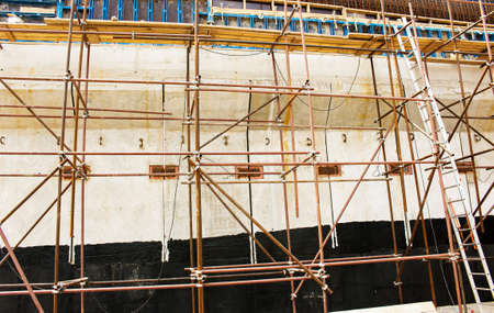 Construction site with scaffolding tower and building. Scaffolding for a construction factory.
