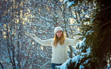 Happy woman plays with a snow in sunny winter day. Girl enjoys winter, frosty day. Playing with snow...