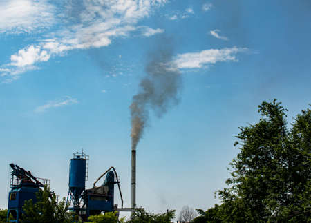 Smoke from chemical factory chimney on cloudy sky background. Ecology theme.