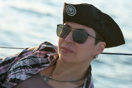 A luxurious yacht vacation. Happy beautiful middle-aged woman in sunglasses on the boat deck floats...