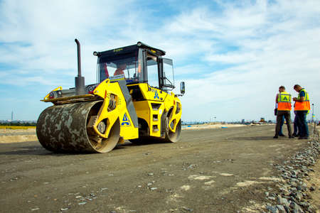 Dnepropetrovsk, Ukraine - 08.17.2021: Asphalt roller rolling asphalt on the new road. Road...