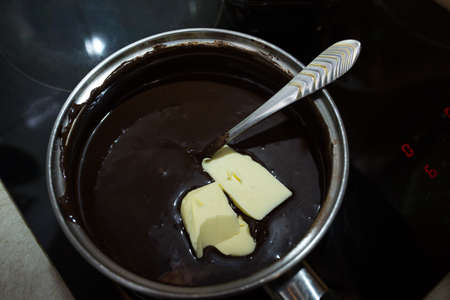 The process of making chocolate glaze. Step by step. The ingredients are mixed in a saucepan. Warm...