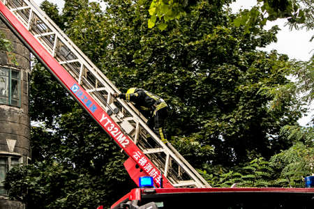 Dnepropetrovsk, Ukraine -09.20.2021: Fire in a residential five-story building. Fire escape and fireman climbing to the scene of the tragedy.のeditorial素材