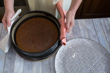 Step by step the process of making sour cream pie dough. The pie is ready. Female hands lay out the baked dough on a dish. Baking concept.の写真素材