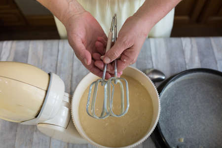 Step by step the process of making sour cream pie dough. Female hands pour the finished raw dough into a prepared baking dish. Baking concept.の写真素材