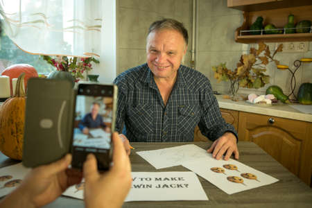 How to make Jack O'Lantern at home? Women's hands photograph the making of Jack O'Lantern at home. Selective focus and bokeh.の写真素材
