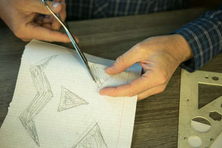 Making Jack O'Lantern at home. Jack O'Lantern thread template creation process. The man prepares the...