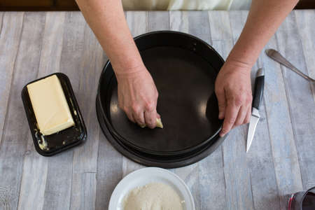 A step-by-step process for making a sour cream chocolate cake. Women's hands prepare a baking dish,...