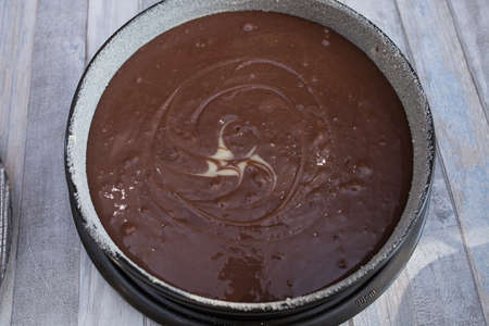 A step-by-step process for making a sour cream chocolate cake. Female hands pour the finished raw...