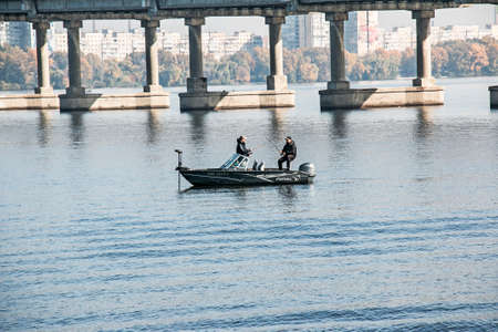 Dnepropetrovsk, Ukraine - 10.15.2021: Fishermen on boats in autumn on the Dnieper river. Active recreation concept.のeditorial素材