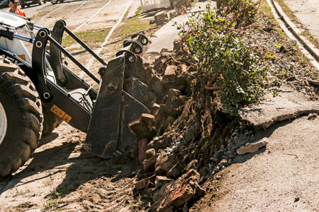 Dnepropetrovsk, Ukraine - 09.15.2021: Excavator, grader and workers remove debris after dismantling...