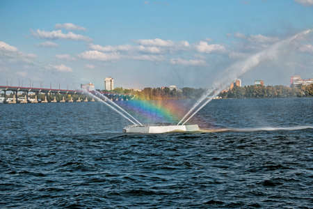 Close-up view of fountain with a beautiful rainbow. Blue sky background. A rainbow made in water fountain.の写真素材