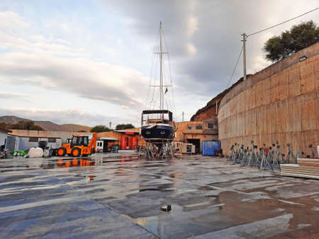 Bodrum, Turkey - 10.12.2021: Modern sailing yacht at the shipyard. Sport yacht docked in dry dock on the shore of boat marina. Kairos Marina.のeditorial素材