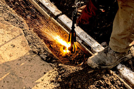 Close-up of the hand of an industrial worker working on the process of cutting rails. A male worker...