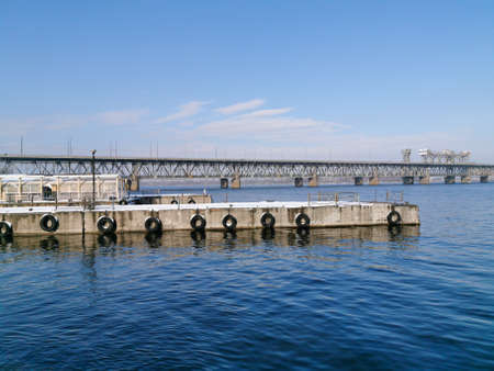 Winter view of the abandoned river piers on the Dnieper. Rusty bollards in the snow. The piers are...
