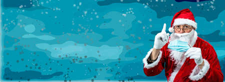 Santa Claus explains the importance of a medical mask during the virus pandemic. New Year card on a snowy background.の写真素材