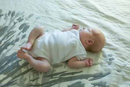 Newborn baby girl lies on the bed. The baby has just turned two weeks old. Newborn care concept.