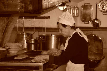 Regensburg, Bavaria, Germany - 11.11.2014: A woman prepares traditional German grilled sausages. Gashtet in the old part of the city.のeditorial素材