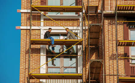 Dnipropetrovsk, Ukraine - 11.22.2021: Builders carry out finishing works of the facade on the...