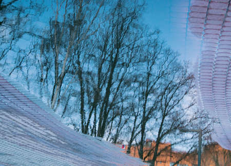 Reflection of tree branches in a puddle after rain. spring background.の写真素材