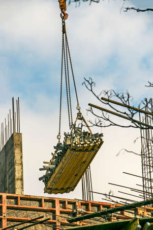 High-rise construction crane with a long yellow boom against the blue sky.の写真素材