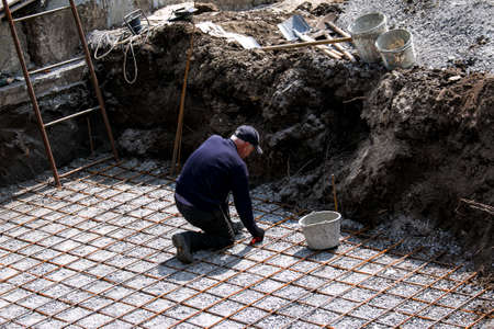 Dnepropetrovsk, Ukraine - 04.30.2021: Preparation of rebar for a concrete pad for a swimming pool.のeditorial素材