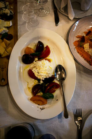 A typical Italian dish of tomato slices and mozzarella cheese seasoned with olive oil sauce.の写真素材