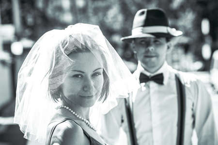 Portrait of a young couple in wedding attire celebrating their wedding anniversary in black and...