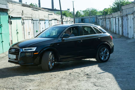 Dnepropetrovsk, Ukraine - 08/06/2022: A man driving an Audi Q3 car in black. Subcompact luxury crossover Audi Q3.のeditorial素材