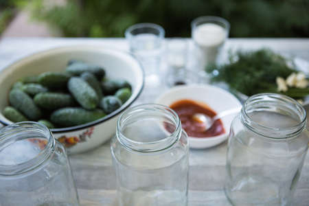 The process of preserving pickled cucumbers for the winter. Ingredients for preservation: dill, peeled garlic, hot peppers, ketchup, salt, sugar, vinegar and cucumbers are prepared for pickling.の写真素材