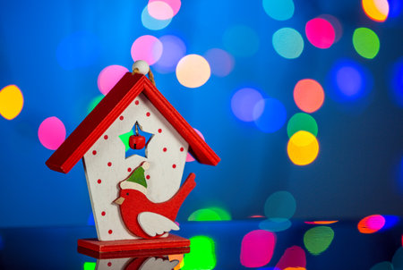 Christmas toy house with a titmouse bird, sparkling and fabulous background with copy space. Christmas background for postcards. Christmas decoration concept.の写真素材