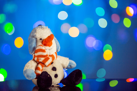 Happy snowman toy sparkling and fabulous bokeh background with copy space. Christmas background for postcards. Christmas decoration concept.の写真素材
