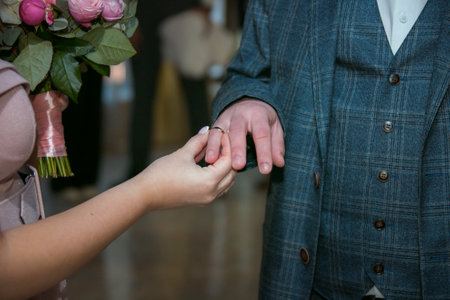 The bride and groom exchange wedding rings in the church during a Christian wedding ceremonyの写真素材