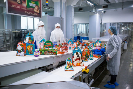 Dnepropetrovsk, Ukraine - 12.08.2017: Workers of a confectionery factory in Santa Claus costumes present New Year's products. On the boxes are the words in Russian and Ukrainian Happy New Year.のeditorial素材