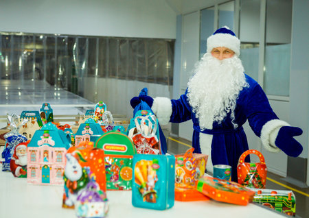 Dnepropetrovsk, Ukraine - 12.08.2017: Workers of a confectionery factory in Santa Claus costumes present New Year's products. On the boxes are the words in Russian and Ukrainian Happy New Year.のeditorial素材
