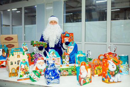 Dnepropetrovsk, Ukraine - 12.08.2017: Workers of a confectionery factory in Santa Claus costumes present New Year's products. On the boxes are the words in Russian and Ukrainian Happy New Year.のeditorial素材