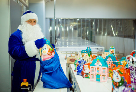 Dnepropetrovsk, Ukraine - 12.08.2017: Workers of a confectionery factory in Santa Claus costumes present New Year's products. On the boxes are the words in Russian and Ukrainian Happy New Year.のeditorial素材