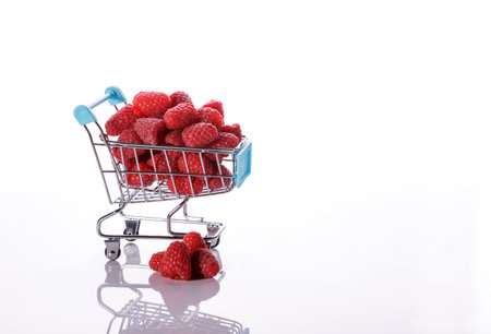 Juicy red fresh raspberries in a food cart on a white background. Full depth of field.の写真素材