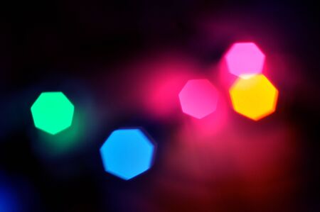 Glowing and festive colored light circles created from in camera and lens bokeh. Christmas fairy lights defocused giving a blurred effect. Background for design.の写真素材