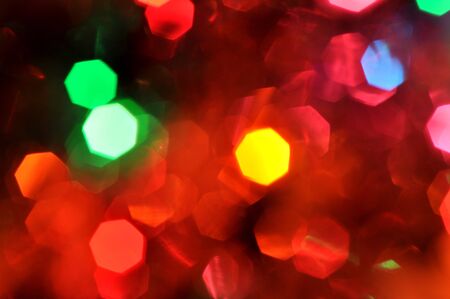 Glowing and festive colored light circles created from in camera and lens bokeh. Christmas fairy lights defocused giving a blurred effect. Background for design.の写真素材