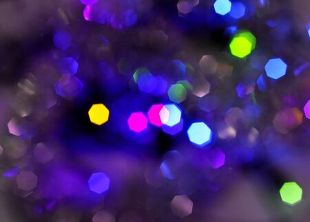 Glowing and festive colored light circles created from in camera and lens bokeh. Christmas fairy lights defocused giving a blurred effect. Background for design.の写真素材