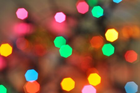 Glowing and festive colored light circles created from in camera and lens bokeh. Christmas fairy lights defocused giving a blurred effect. Background for design.の写真素材