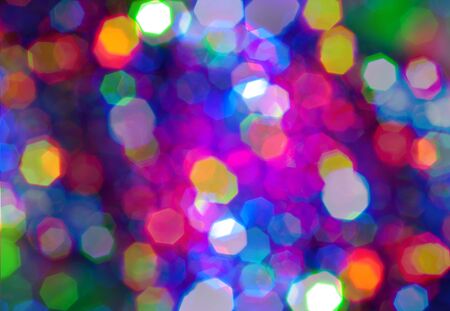 Glowing and festive colored light circles created from in camera and lens bokeh. Christmas fairy lights defocused giving a blurred effect. Background for design.の写真素材