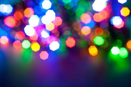Glowing and festive colored light circles created from in camera and lens bokeh. Christmas fairy lights defocused giving a blurred effect. Background for design.の写真素材
