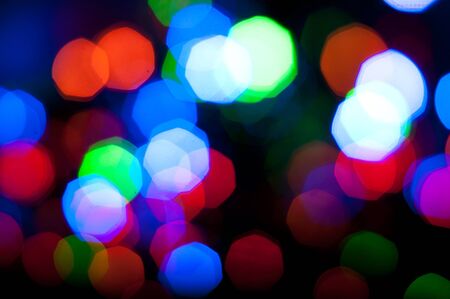 Glowing and festive colored light circles created from in camera and lens bokeh. Christmas fairy lights defocused giving a blurred effect. Background for design.の写真素材