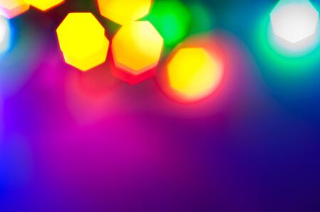 Glowing and festive colored light circles created from in camera and lens bokeh. Christmas fairy lights defocused giving a blurred effect. Background for design.の写真素材