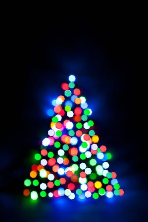 Glowing and festive colored light circles created from in camera and lens bokeh. Christmas fairy lights defocused giving a blurred effect. Background for design.の写真素材
