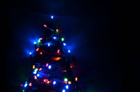 Glowing and festive colored light circles created from in camera and lens bokeh. Christmas fairy lights defocused giving a blurred effect. Background for design.の写真素材