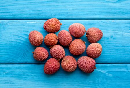Lychee fruit on blue wooden background. Fresh lychee tropical fruit.