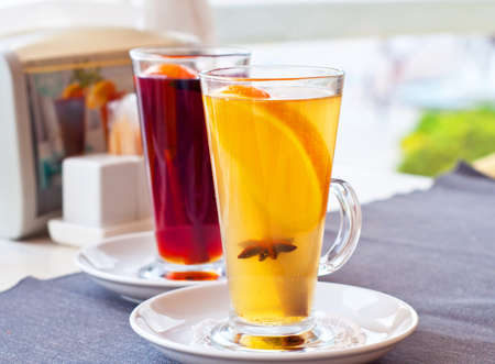 Mulled wine in tall glasses in a cafe. Warming drink with fruits and spices.の写真素材